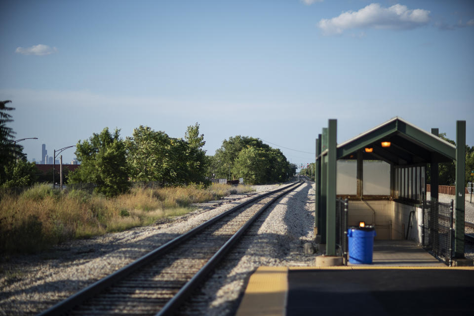 The downtown skyline stands in the distance at left as a Metra train line station sits empty during rush hour in the Auburn Gresham neighborhood in Chicago, Thursday, Aug. 27, 2020. In Chicago, one of the nation's most segregated cities, nearly 43 percent of the virus' victims have been Black, more than twice the number of whites. (AP Photo/David Goldman)