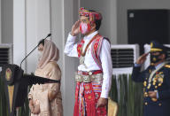 In this photo released by Indonesian Presidential Palace, Indonesian President Joko Widodo, dressed in traditional dress and wearing a face mask as a precaution against the coronavirus, salutes as his wife Iriana, left, looks on, during a flag hoisting ceremony commemorating the country's 75th Independence Day at Merdeka Palace in Jakarta, Indonesia, Monday, Aug. 17. 2020. Indonesia gained its independence from the Dutch colonial rule in 1945. (Agus Suparto, Presidential Palace via AP)