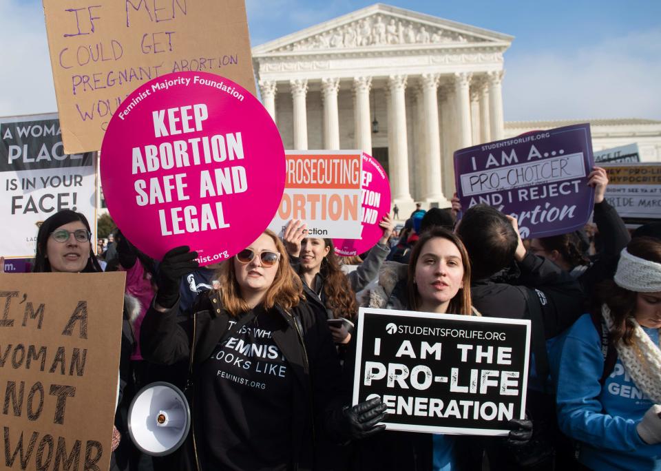 Pro-choice activists hold signs Jan. 18 alongside anti-abortion activists participating in the "March for Life" in Washington, D.C.