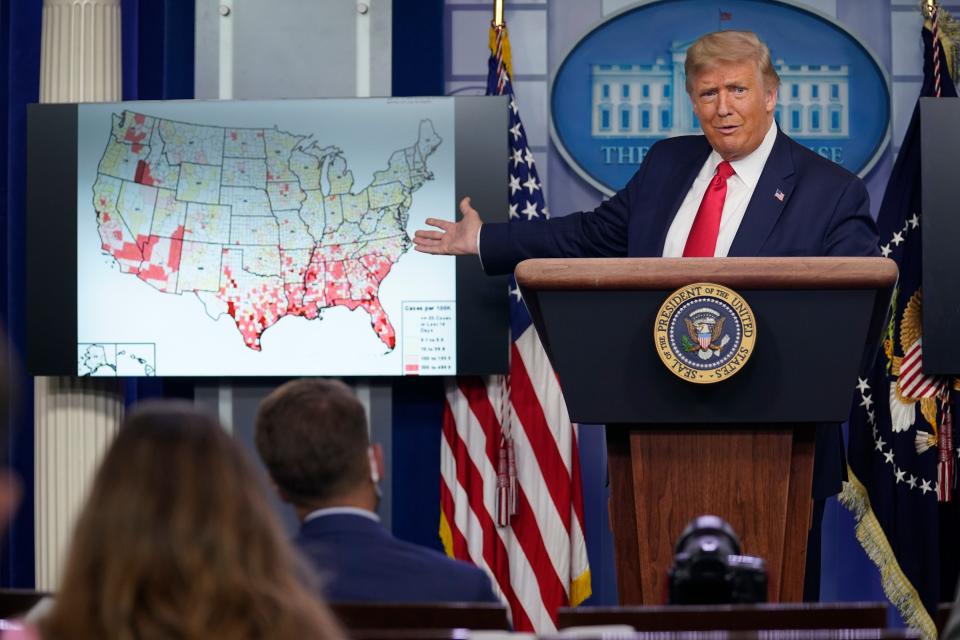 President Donald Trump gestures towards a screen displaying a graphic on the coronavirus outbreak as he speaks during a news conference at the White House, Thursday, July 23, 2020, in Washington. (AP Photo/Evan Vucci)