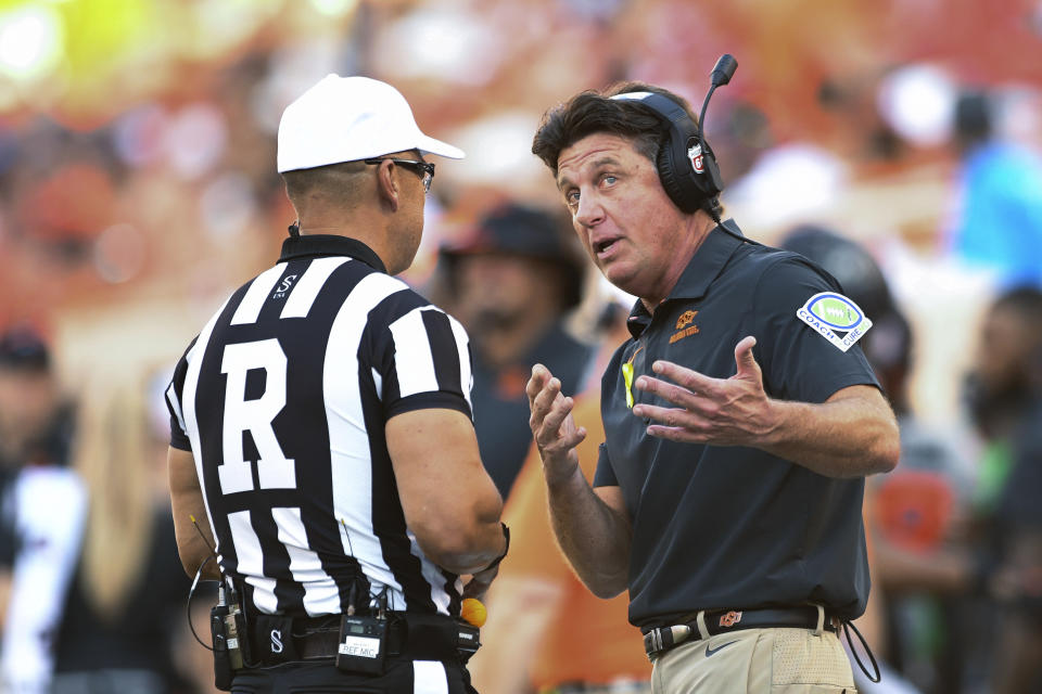 Oklahoma State coach Mike Gundy speaks with an official during a timeout in the first half of the team's NCAA college football game against Arkansas-Pine Bluff on Saturday, Sept. 17, 2022, in Stillwater, Okla. Oklahoma State won 63-7. (AP Photo/Brody Schmidt)