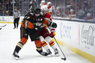 Calgary Flames center Connor Zary (47) and Anaheim Ducks left wing Alex Killorn (17) vie for the puck during the second period of an NHL hockey game Friday, April 12, 2024, in Anaheim, Calif. (AP Photo/Kyusung Gong)