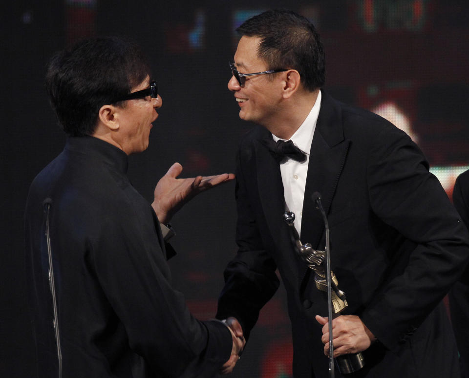 Hong Kong director Wong Kar Wai, right, receives his Best Film Award for his movie ' The Grandmaster ' from Hong Kong actor Jackie Chan, left, at the 33rd Hong Kong Film Awards in Hong Kong, Sunday, April 13, 2014. (AP Photo/Vincent Yu)