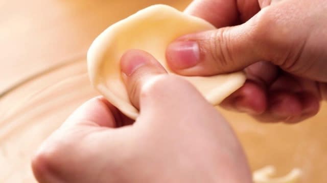 Shaping dough into a flat circle with thumbs