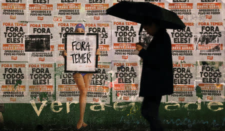 People walk past a sign reading "Out Temer" at the end of a protest against Brazil's President Michel Temer in Sao Paulo, Brazil, May 21, 2017. REUTERS/Nacho Doce