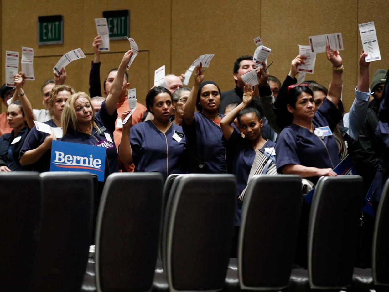 Casino workers hold up presidential preference cards as they support Democratic presidential candidate Bernie Sanders during a presidential caucus at the Bellagio hotel-casino: AP