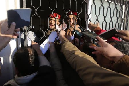 Palestinians, hoping to cross into Egypt, present their passports at the Rafah crossing between Egypt and the southern Gaza Strip December 21, 2014. REUTERS/Ibraheem Abu Mustafa