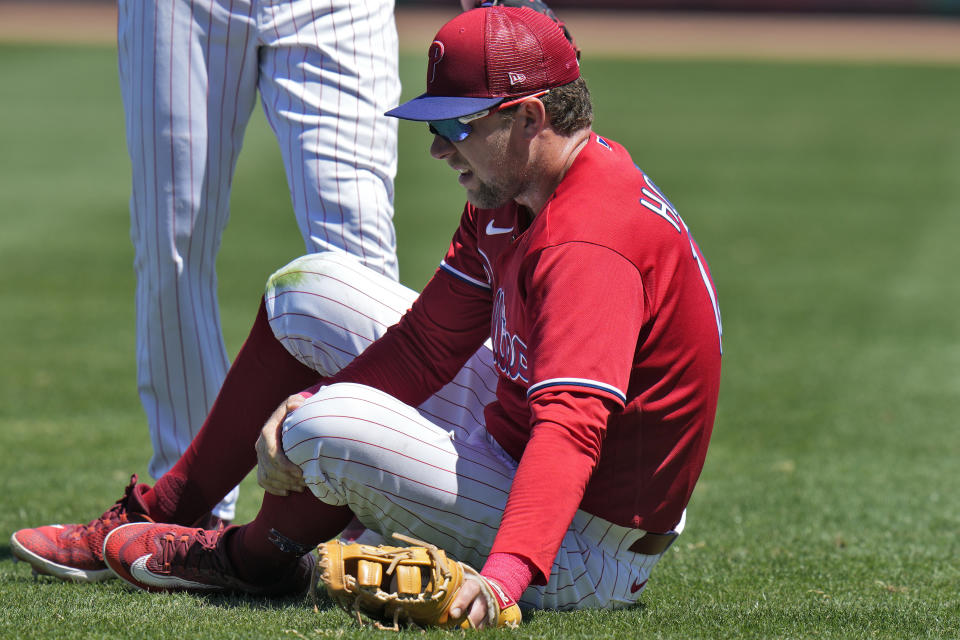 Philadelphia Phillies first baseman Rhys Hoskins grabs his leg after getting hurt fielding a ground ball by Detroit Tigers' Austin Meadows during the second inning of a spring training baseball game Thursday, March 23, 2023, in Clearwater, Fla. Hoskins had to be carted off the field. (AP Photo/Chris O'Meara)