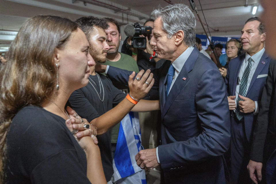 FILE - Secretary of State Antony Blinken is embraced by Lior Gelbaum, left, 24, a dual U.S.-Israeli citizen, and her boyfriend Klil Valiano, Oct. 12, 2023, in Tel Aviv, at a donation center for victims of the Hamas attacks. AP Washington photographer Jacquelyn Martin recalls how being one of a few female photographers covering news and politics was useful when she was assigned as the press pooler for Blinken's last-minute trip to Israel and the Middle East in the aftermath of the Hamas attacks. Martin said, “Sometimes people not knowing what to make of you works in your favor.” (AP Photo/Jacquelyn Martin, Pool, File)