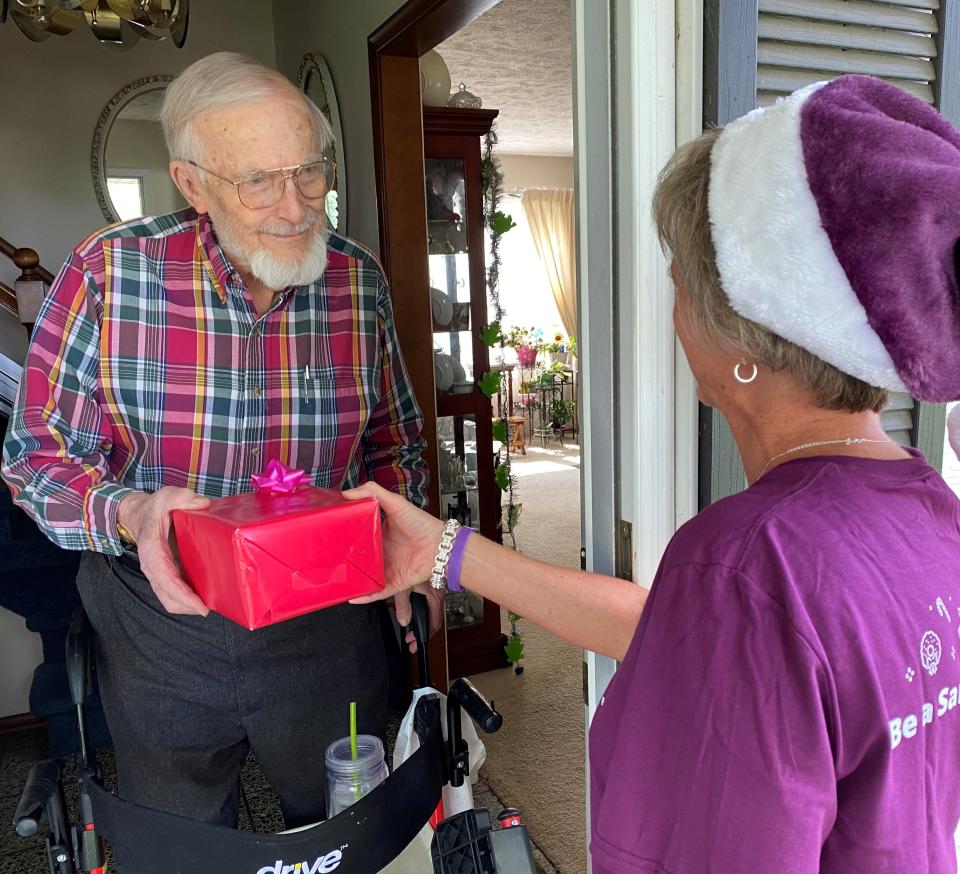 FILE - A Home Instead volunteer takes a gift to a senior adult as part of its holiday program.