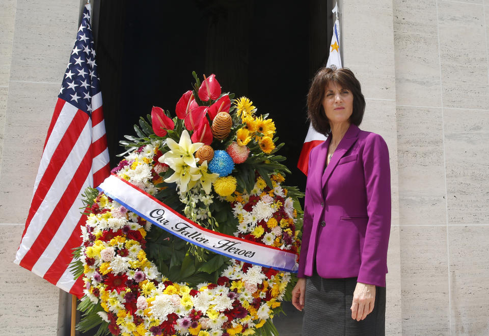 Denise Natali, U.S. Assistant Secretary Bureau of Conflict and Stabilization Operations, stands beside a wreath during a wreath-laying ceremony for the more than 17,000 US troops killed during WWII at the American Cemetery Tuesday, June 4, 2019 in suburban Taguig city east of Manila, Philippines. Natali is here to discuss with Philippine security officials a new program to help thwart efforts by Muslim extremists to recruit and mobilize followers after a bloody siege by jihadists aligned with the Islamic State group. (AP Photo/Bullit Marquez)