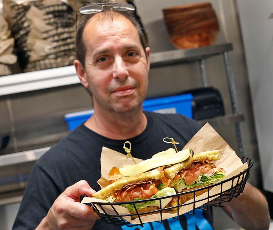 Cook Joel Hathaway with sandwich from the kitchen at Kilroy's Square at 24 Cottage Ave. in downtown Quincy.