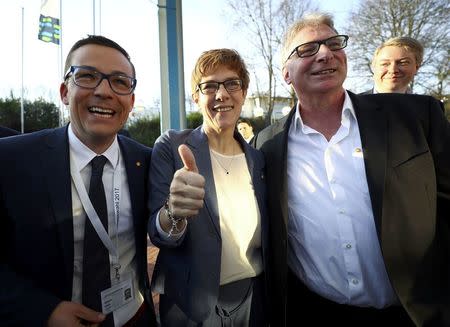 Annegret Kramp-Karrenbauer, State Minister-President and top candidate of the Christian Democratic Union Party (CDU), her husband Helmut (R) and Roland Theis of the CDU (L) react on first exit polls after the Saarland state elections in Saarbruecken, Germany, March 26, 2017. REUTERS/Kai Pfaffenbach