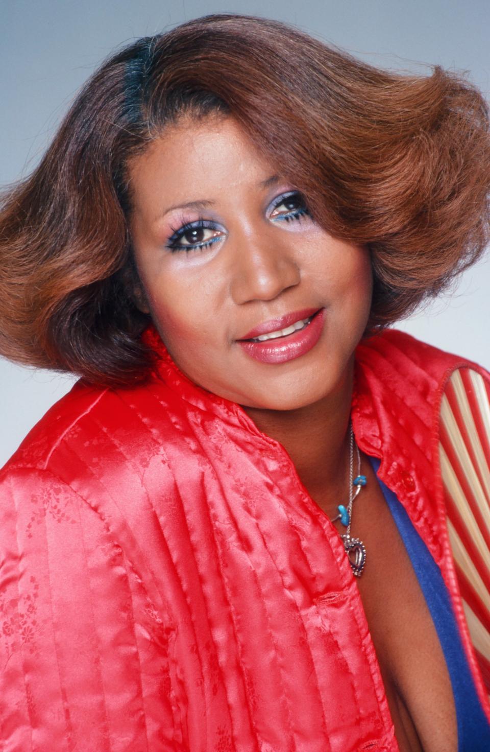 <p>Bring on the glam! Aretha Franklin poses for a portrait rocking a caramel-colored flipped hairstyle, blue eyeliner, and cherry red lipstick to match her bomber jacket. (Photo by Harry Langdon/Getty Images) </p>