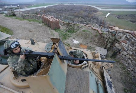 Turkish soldiers on an armoured military vehicle survey the border line between Turkey and Syria, near the southeastern city of Kilis, Turkey, March 2, 2017. REUTERS/Murad Sezer