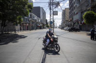 A Palestinian man wears a face mask as he rides a motorcycle during a lockdown imposed following the discovery of coronavirus cases in the Gaza Strip, Thursday, Aug. 27, 2020. On Wednesday Gaza's Hamas rulers extended a full lockdown in the Palestinian enclave for three more days as coronavirus cases climbed after the detection this week of the first community transmissions of the virus in the densely populated, blockaded territory. (AP Photo/Khalil Hamra)