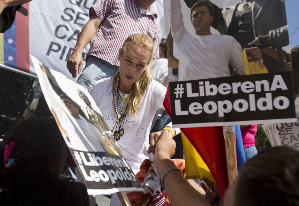 Lilian Tintori, esposa del líder opositor detenido Leopoldo López, saluda a los partidarios durante una manfestación para conmemorar el primer mes de su detención, cerca de la prisión de Cabo Verde, donde está detenido, en Los Teques, Venezuela, el martes 18 de marzo de 2014. (Foto AP/Esteban Félix)