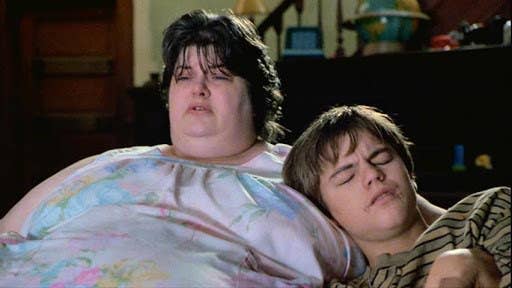 Cates reclines on her couch with her son played by leonardo dicaprio leaning against her