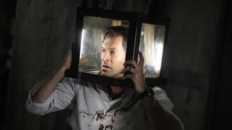 a man's head is trapped in a glass box in a scene from saw v