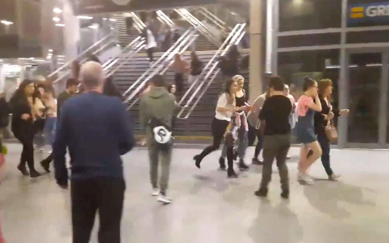 People running through Manchester Victoria station after an explosion at Manchester Arena. - PA