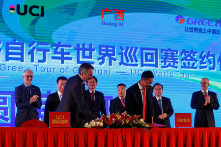 President of the Union Cycliste Internationale (UCI) Brian Cookson, Wanda Group Chairman Wang Jianlin, Guangxi autonomous region official Lan Tianli and Wang Jingdong of Gree Electric Appliances (background L- 4th R) attend a signing ceremony for a China hosted Union Cycliste Internationale (UCI) world tour cycling race in Beijing, China, December 1, 2016. REUTERS/Thomas Peter