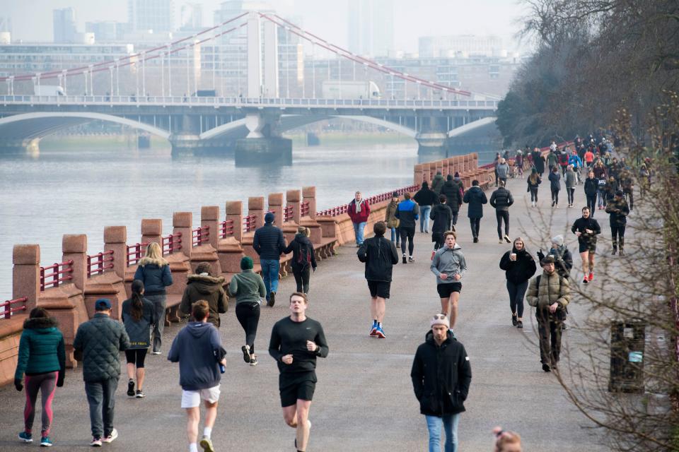 <p>People walk and run through Battersea Park during England's third national lockdown</p> (PA)