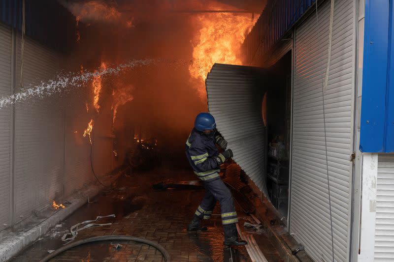 Firefighters spray water onto fire at the market after shelling in Sloviansk