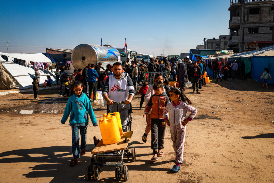 Youssef Al-Khishawi, an MSF water and sanitation agent, helps children carry water to their tent in the Tal Al-Sultan area of the southern Gaza town of Rafah, on January 27, 2024.
He says: â€œIn a normal situation, one person needs two to three litres of drinking water per day. Now, with the current shortage, the average for one family of six is one gallon of water (3.8 litres).