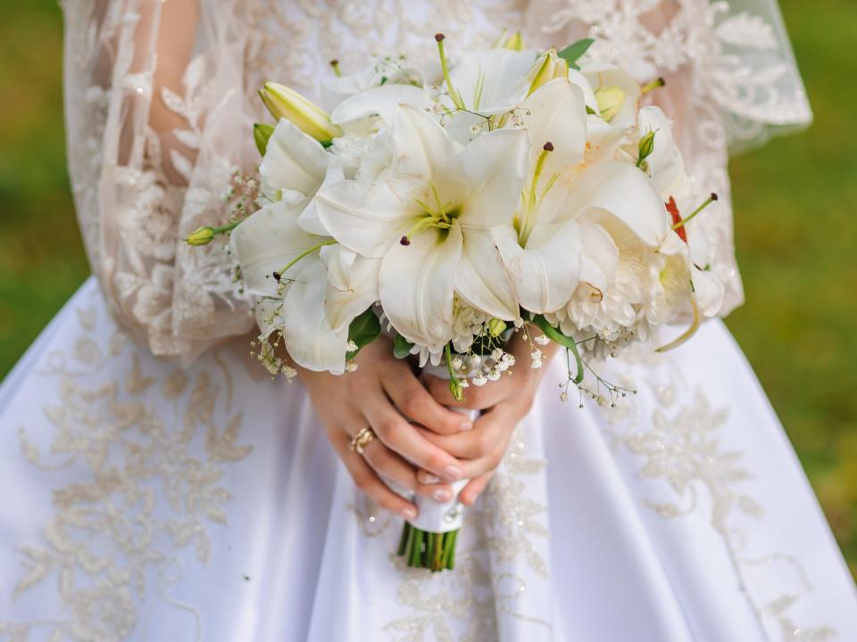 Bouquet of white flowers in the hand of the bride
