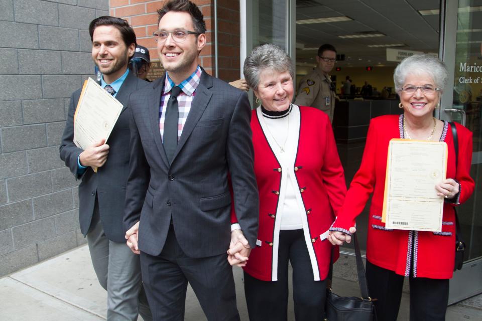 The first two couples to receive marriage licenses minutes after gay marriage was legalized in Arizona come out of the Clerk of the Superior Court all smiles in Phoenix, Friday, October 17, 2014.  From left to right are; David Larance, 36, Kevin Patterson, 31, both Phoenix, and Nelda Majors, 76, and Karen Bailey, 75, both Scottsdale.