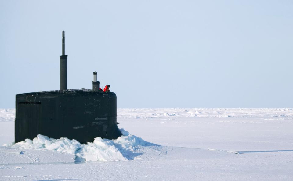 A US Navy sailor looks off the bridge of the Seawolf class submarine USS Connecticut after surfacing through Arctic sea ice during an exercise in Alaska in March 2011.