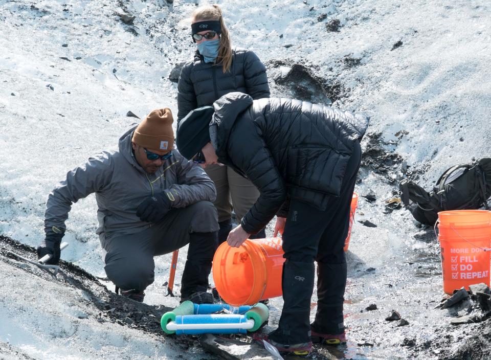 (From left) Carlos Colon, an Armed Forces Medical Examination System medical legal investigator, U.S. Air Force Capt. Lyndi Minott, Operation Colony Glacier deputy planner assigned to Air Force Mortuary Affairs Operations, and Katherine Grosso, an AFMES medical legal investigator, filter water in search of remains at Colony Glacier, Alaska, June 17, 2021. Operation Colony Glacier is an effort to recover the remains of service members and wreckage from a C-124 aircraft that crash landed in November 1952 with 52 military members on board. The wreckage was discovered in 2012 and a recovery effort has taken place each summer.