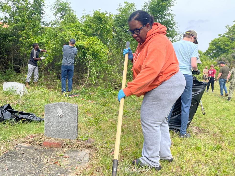 Savilla Davis-Murphy cleans around her father’s headstone during Saturday’s community cleanup at Good Hope A.M.E. Church Cemetery in Warrington. More than 100 volunteers attended the cleanup of the 19th century cemetery.