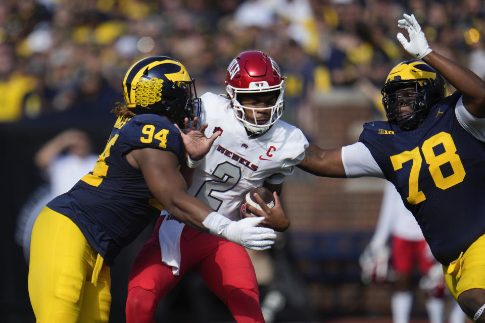 UNLV quarterback Doug Brumfield (2) is sacked by Michigan defensive linemen Kris Jenkins (94) and Kenneth Grant (78) in the first half of an NCAA college football game in Ann Arbor, Mich., Saturday, Sept. 9, 2023. (AP Photo/Paul Sancya)