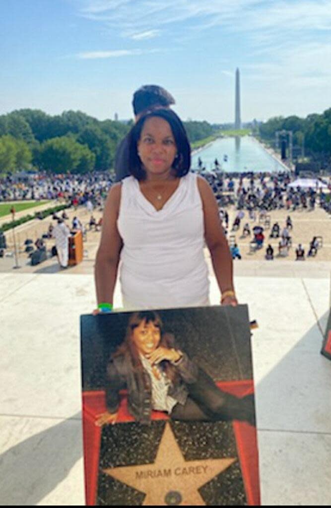 Valarie Carey Reaves-Bey holds a picture of her sister Miriam Carey during the March on Washington at the Lincoln Memorial, Aug. 28, 2020.