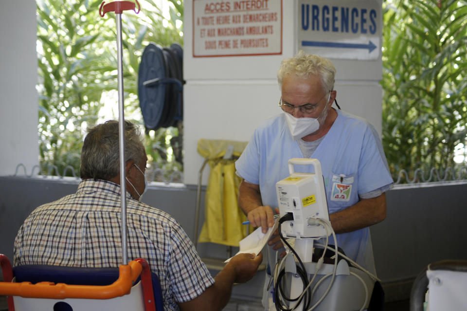 People wait at the emergency service of the hospital in Papeete, Tahiti island, French Polynesia, Friday Aug.20, 2021. France's worst virus outbreak so far is unfolding 12 times zones away from Paris, devastating Tahiti and the idyllic atolls of French Polynesia. It's France's latest challenge in juggling resources to battle the pandemic in former colonies that stretch around the world (AP Photo/Esther Cuneo)