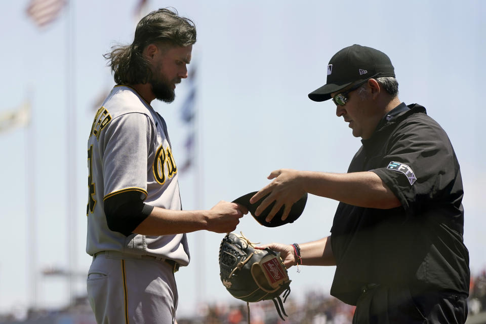 Pittsburgh Pirates pitcher JT Brubaker, left, is inspected by umpire Manny Gonzalez during the first inning of a baseball game against the San Francisco Giants in San Francisco, Sunday, July 25, 2021. (AP Photo/Jeff Chiu)