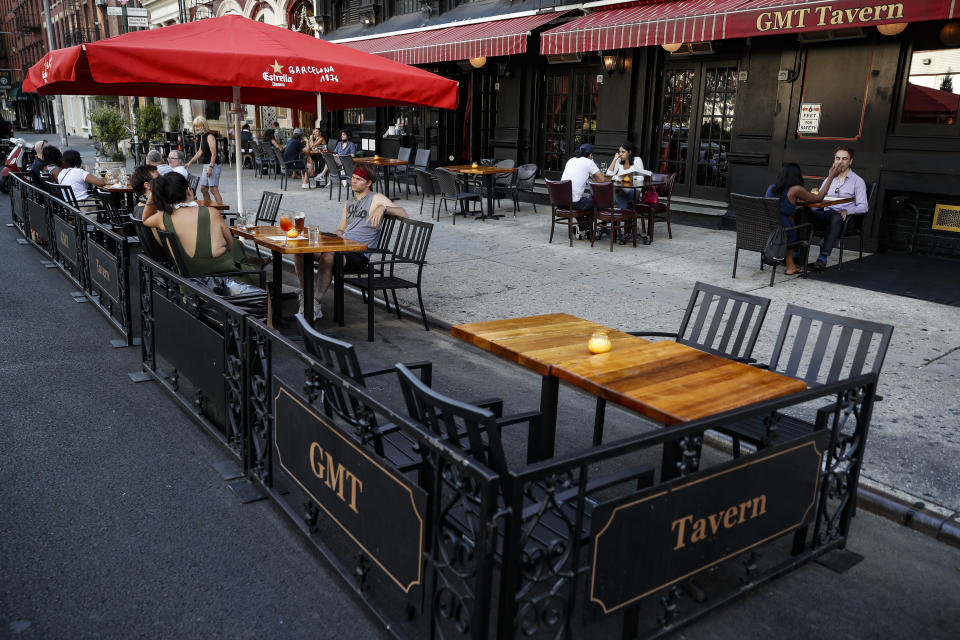 Customers dine outside GMT Tavern, Monday, June 22, 2020, in New York. New York City Mayor Bill de Blasio says he is delaying the planned resumption of indoor dining at restaurants in the city out of fear it would ignite a a spike in coronavirus infections. (AP Photo/John Minchillo)