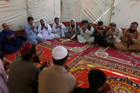 Hiji Behram Khan (top, 3rd L), father of Dilawar, a police cadet who was killed in Monday’s attack on the Police Training College, offers pray with others outside his home on the outskirts of Quetta, Pakistan, October 26, 2016. REUTERS/Akhtar Soomro