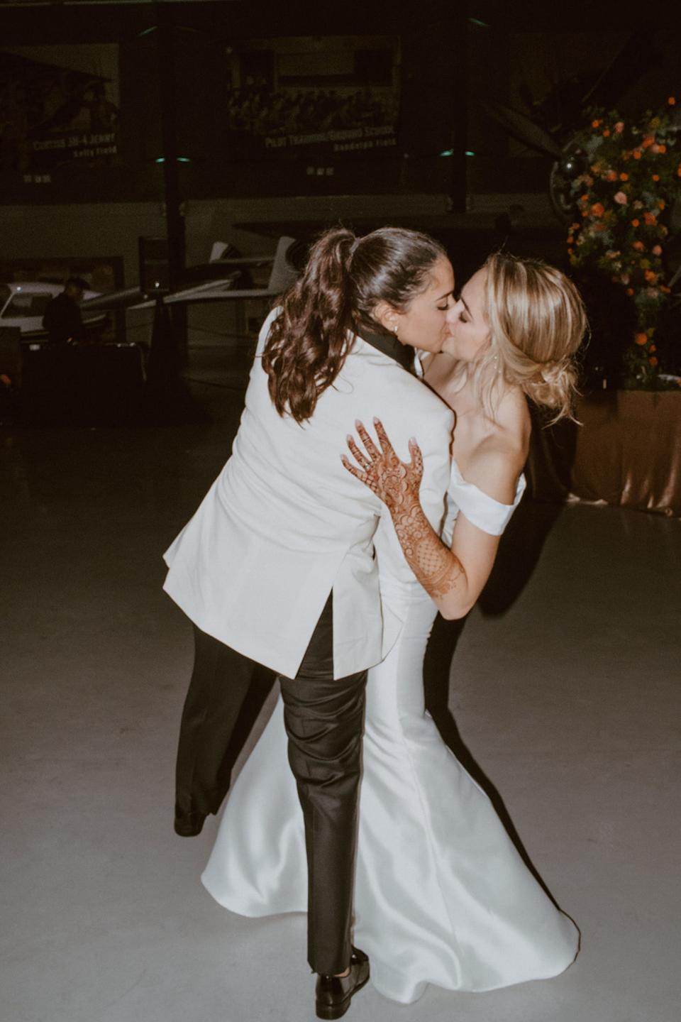 Two brides kiss on their wedding day.