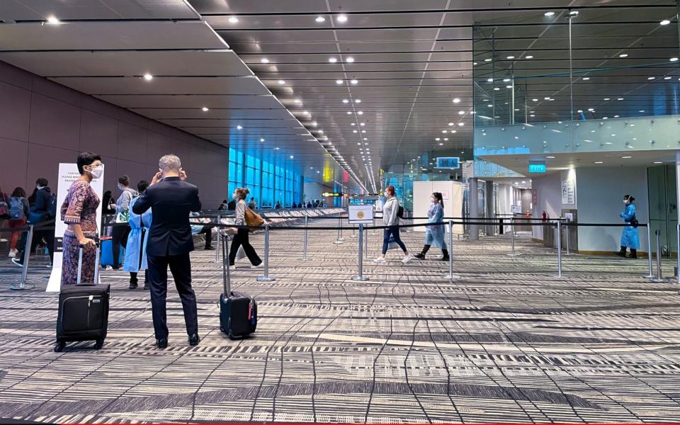 Passengers wearing face masks stand near a terminal gate at Changi International Airport on July 14, 2021 in Singapore, Singapore. Singapore's Changi Airport, one of the world's key transit hubs, has seen passenger numbers plummet as the ongoing Covid-19 pandemic continues to have a severe impact on air travel. - Getty Images