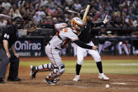 Baltimore Orioles catcher Adley Rutschman, middle, chases down the ball after a pitch as Arizona Diamondbacks' Gabriel Moreno, right, tells a runner on third base to stop as umpire Tom Hanahan (69) watches during the eighth inning of a baseball game Friday, Sept. 1, 2023, in Phoenix. The Diamondbacks won 4-2. (AP Photo/Ross D. Franklin)