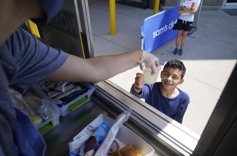 Tiffany Sawczenko hands a drink sample to Michael, no last name given, out of a food truck window Friday, June 18, 2021, in McKinney, Texas. When the pandemic was declared in March 2020, retailers worried about the potential spread of the coronavirus so they cut off free sampling of everything from food to makeup to toys. But now with vaccinations rolling out and the threat of COVID-19 easing in the U.S., food vendors and stores are feeling confident enough to revive the longstanding tradition. (AP Photo/LM Otero)