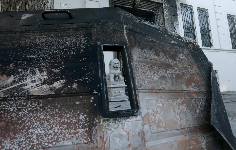 A burned door lies outside the damaged entrance to the Chinese Consulate in San Francisco on Thursday, Jan. 2, 2014. The consulate said in a notice on its website that a person came out of a van parked outside the compound Wednesday night with two buckets of gasoline, poured the fuel on the front of the consulate building and set it on fire. (AP Photo/Jeff Chiu)