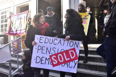 Protesters hold banners outside the University of London, Britain February 22, 2018. REUTERS/Peter Summers