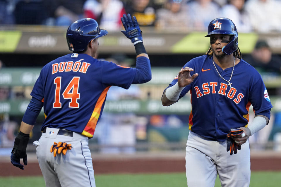 Houston Astros' Martin Maldonado, right, and Mauricio Dubon, left, celebrate after they scored on a single by Astros' Yordan Alvarez off Pittsburgh Pirates starting pitcher Roansy Contreras during the second inning of a baseball game in Pittsburgh, Monday, April 10, 2023. (AP Photo/Gene J. Puskar)