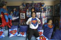 Herbert Chavez poses with his Superman memorabilia inside his house in Calamba Laguna, south of Manila October 12, 2011. In his idolization of the superhero, Chavez, a self-professed "pageant trainer" who owns two costume stores, has undergone a series of cosmetic surgeries for his nose, cheeks, lips and chin down to his thighs and even his skin color to look more like the "Man of Steel". The final result bears little resemblance to his old self. REUTERS/Cheryl Ravelo (PHILIPPINES - Tags: SOCIETY)