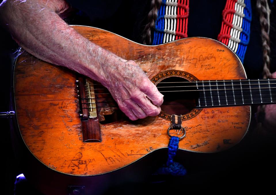 Willie Nelson strums his well-worn guitar, Trigger. Though almost 90, his dexterity and strong playing wowed fans.