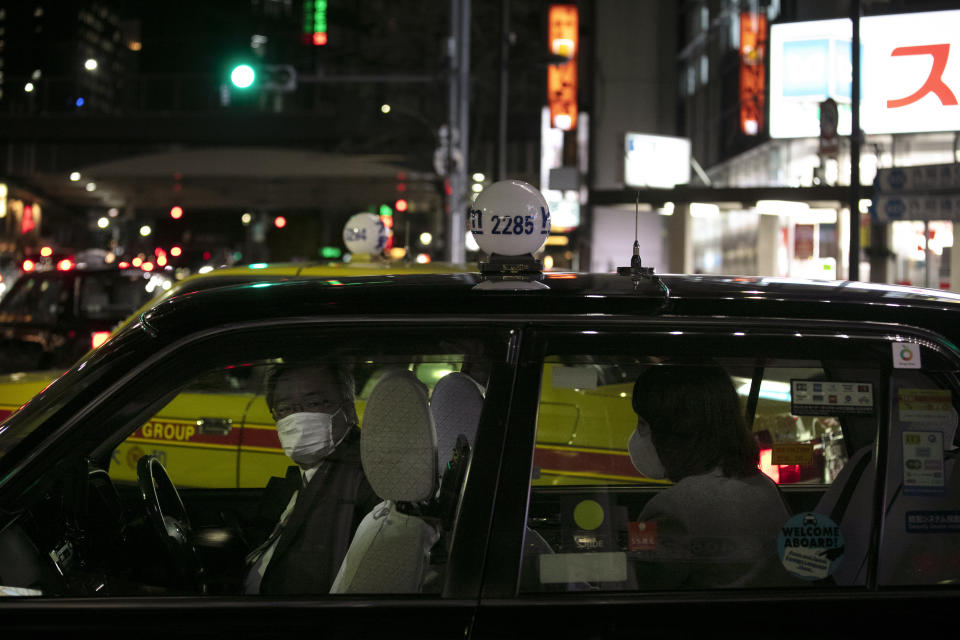 A taxi driver with a mask drops off a passenger near Ginza Station Thursday, Jan. 30, 2020, in Tokyo. The country began evacuating Japanese citizens on Wednesday from the Chinese city Wuhan hardest-hit by the virus. (AP Photo/Jae C. Hong)