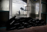 <p>Sandbags sit outside a police station office as a worker secures the grounds of a hotel along the beach ahead of Hurricane Irma in Daytona Beach, Fla., Friday, Sept. 8, 2017. (Photo: David Goldman/AP) </p>